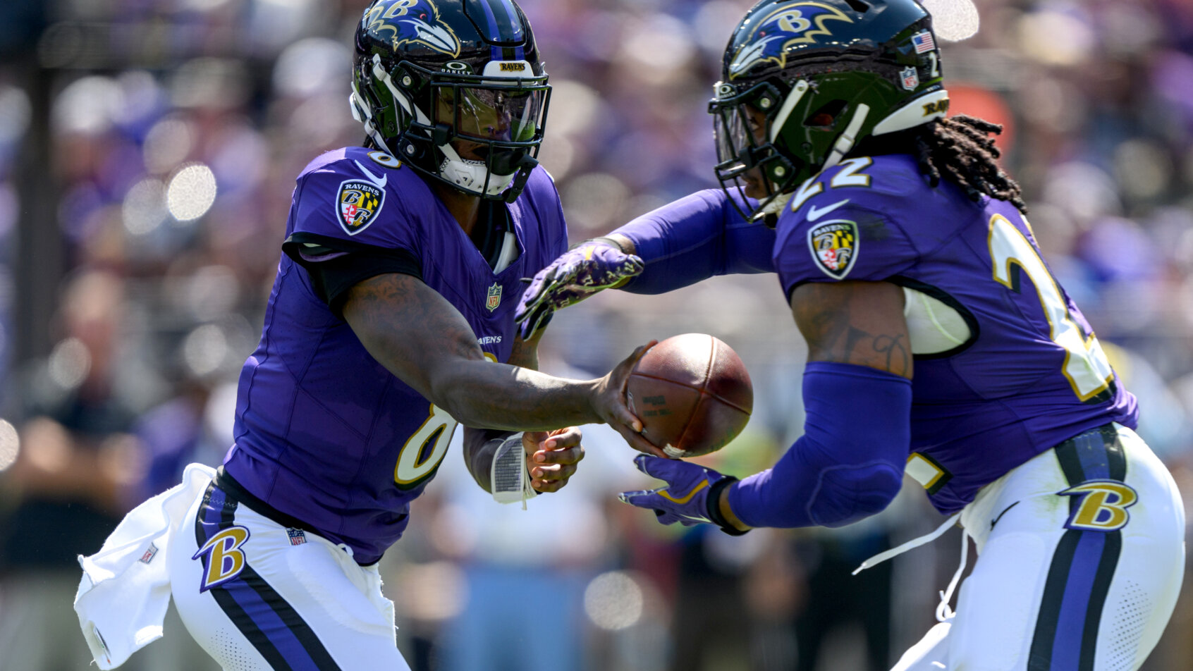 Baltimore Ravens quarterback Lamar Jackson hands off to running back Derrick Henry