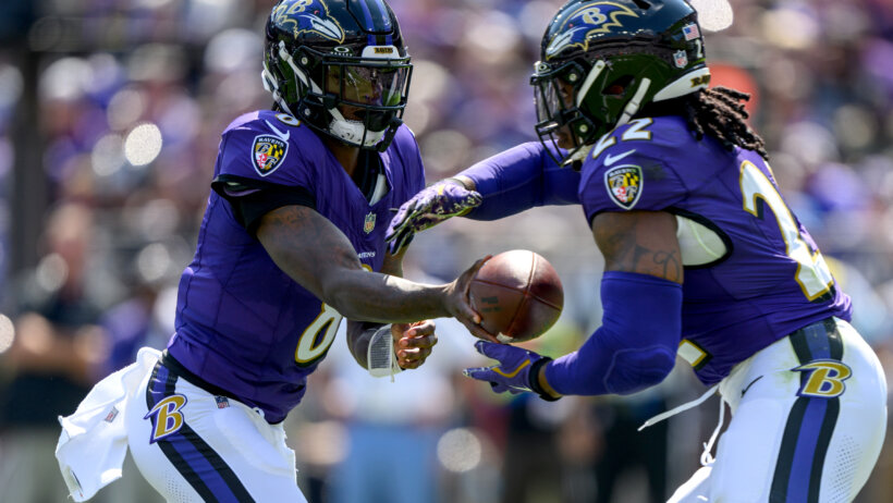 Baltimore Ravens quarterback Lamar Jackson hands off to running back Derrick Henry