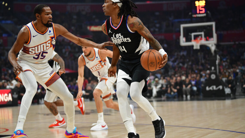Los Angeles Clippers guard Terance Mann dribbles while Phoenix Suns forward Kevin Durant defends