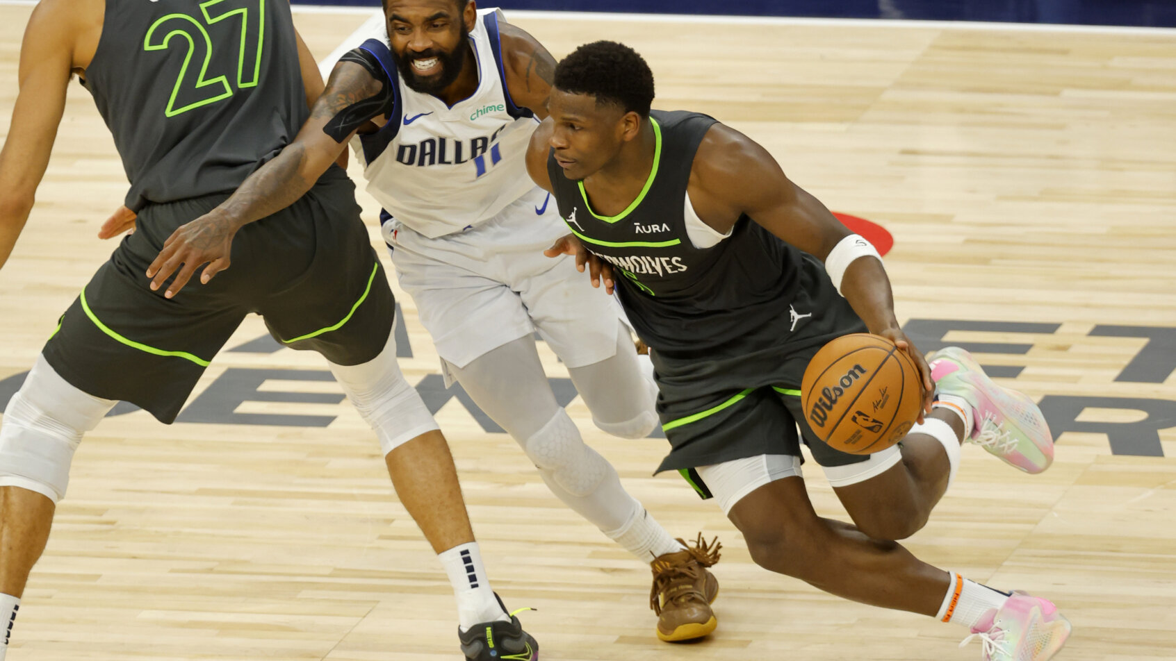 Dallas Mavericks guard Kyrie Irving tries to dribble around Minnesota Timberwolves guard Anthony Edwards