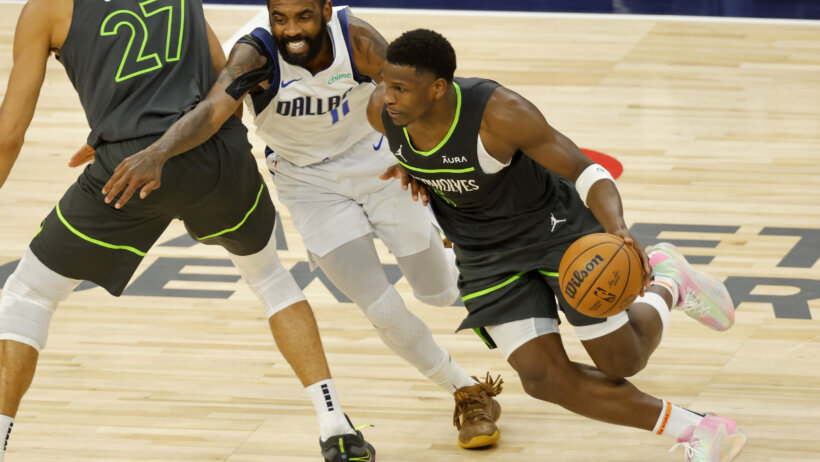 Dallas Mavericks guard Kyrie Irving tries to dribble around Minnesota Timberwolves guard Anthony Edwards