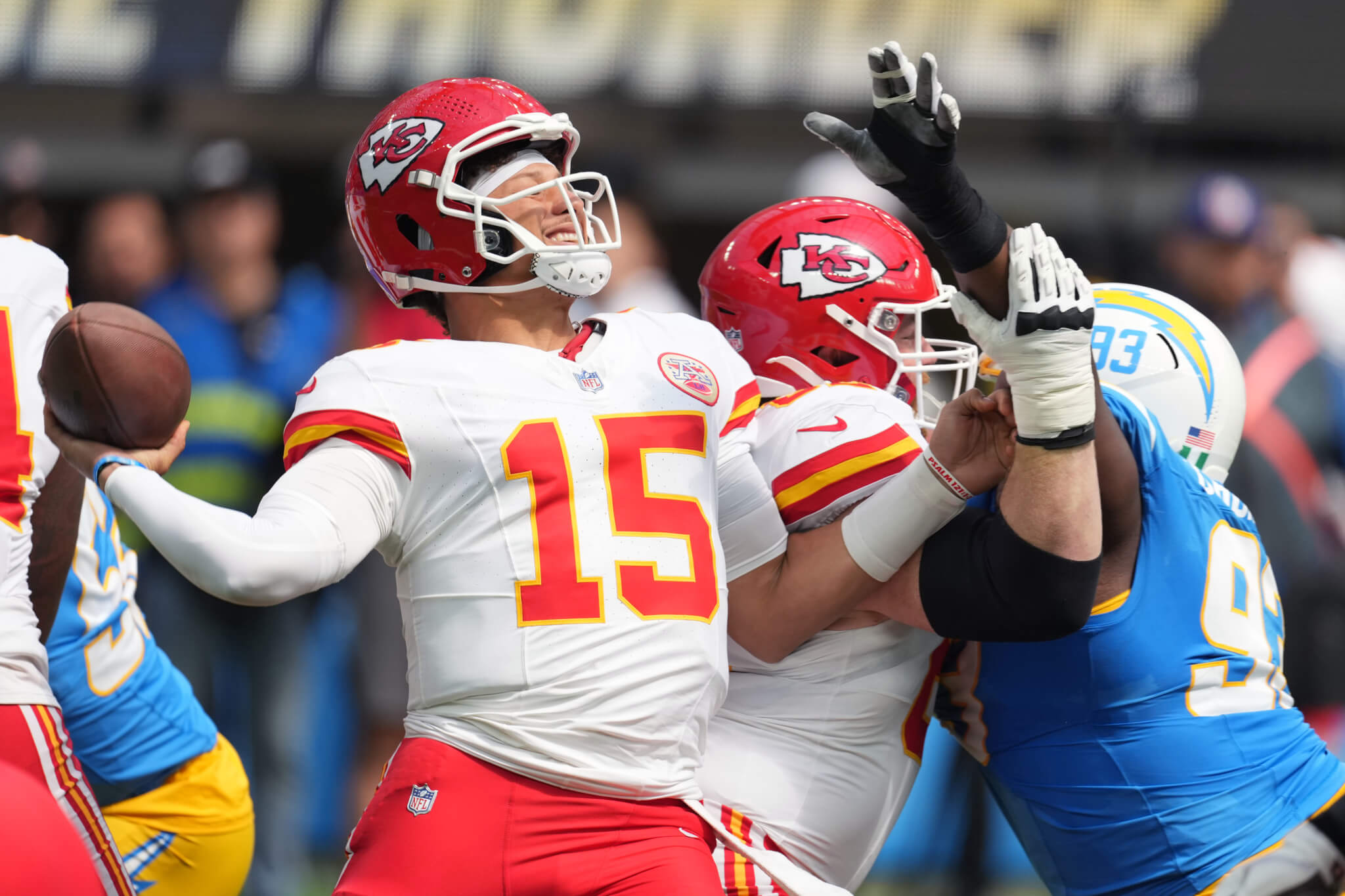 Patrick Mahomes gets hit as he throws the ball.