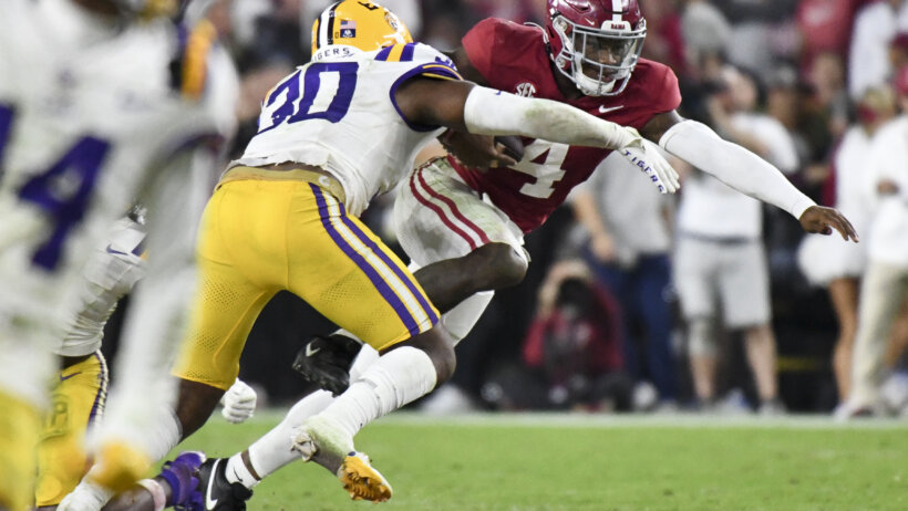 LSU Tigers linebacker Greg Penn III tackling Alabama Crimson Tide quarterback Jalen Milroe