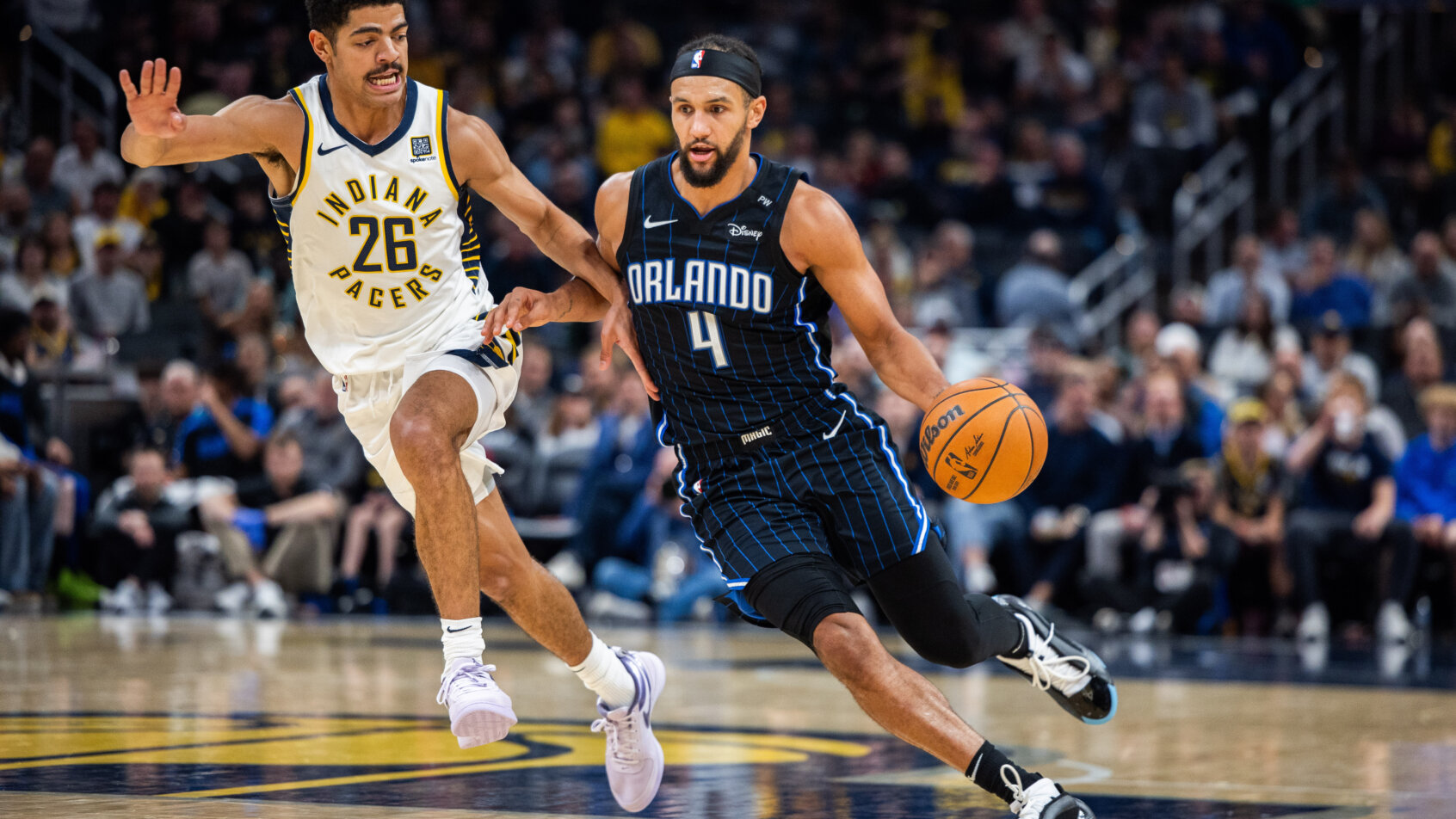 Orlando Magic guard Jalen Suggs dribbling around Indiana Pacers guard Ben Sheppard