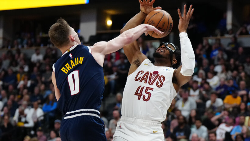 Denver Nuggets guard Christian Braun blocking a shot from Cleveland Cavaliers guard Donovan Mitchell