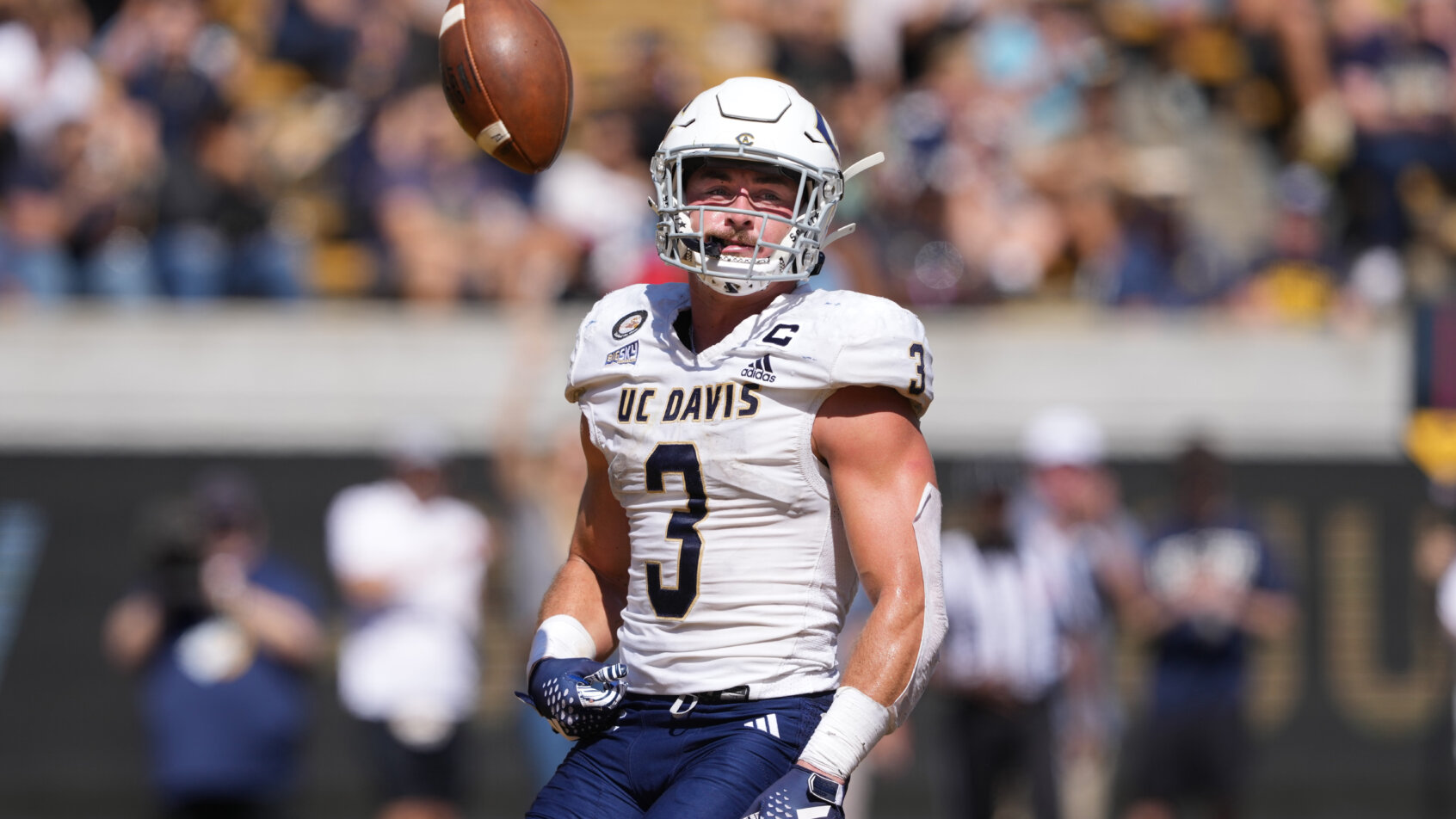 UC Davis Aggies running back Lan Larison (3) flips the ball into the air after scoring a touchdown