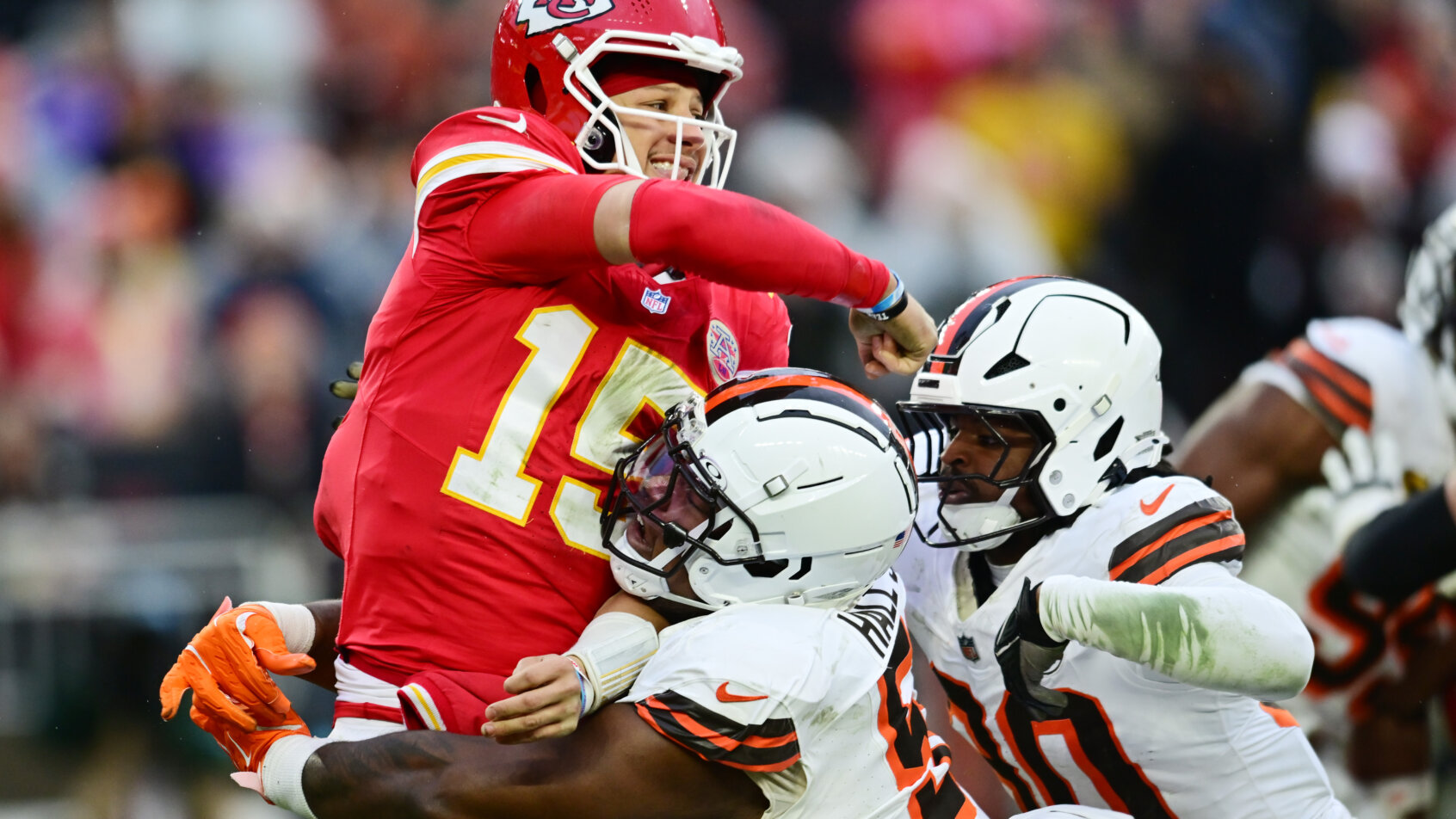 Patrick Mahomes is hit hard by Browns defenders.