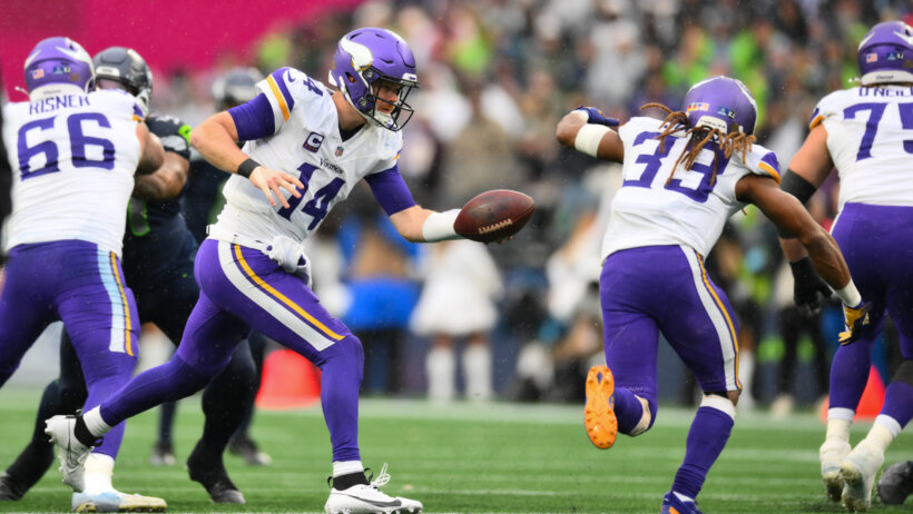 Minnesota Vikings quarterback Sam Darnold hands the ball off to running back Aaron Jones