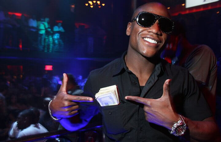 Floyd Mayweather pointing to a wad of cash.