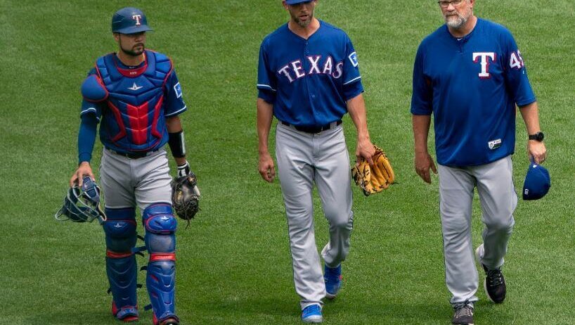 Mike Minor walking to the mound with Ranger teammates and coaches.