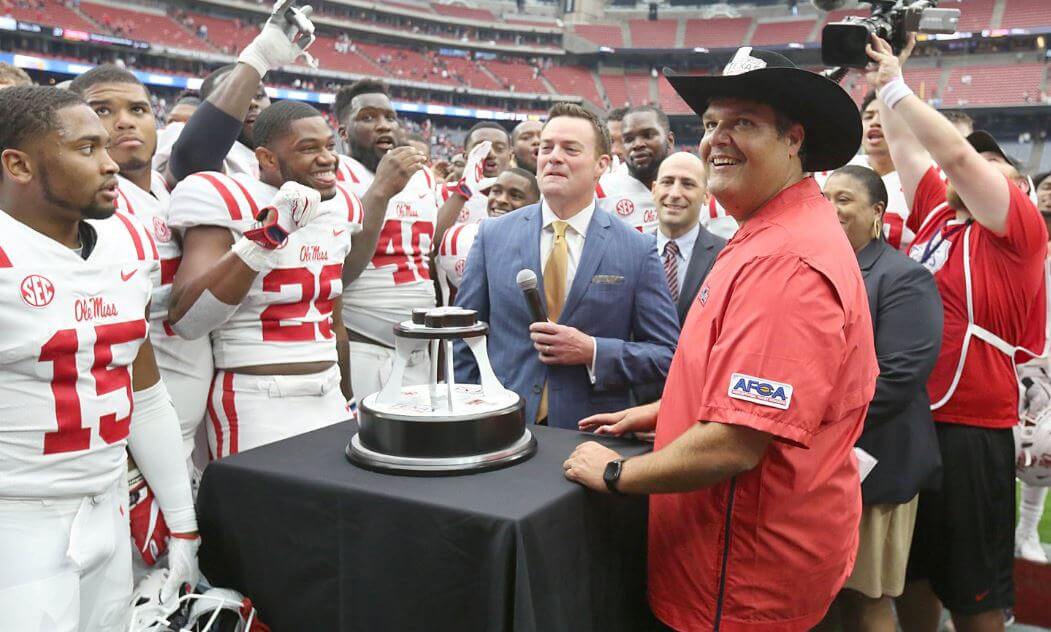 Head coach Matt Luke of the Ole Miss Rebels celebrating with his team.