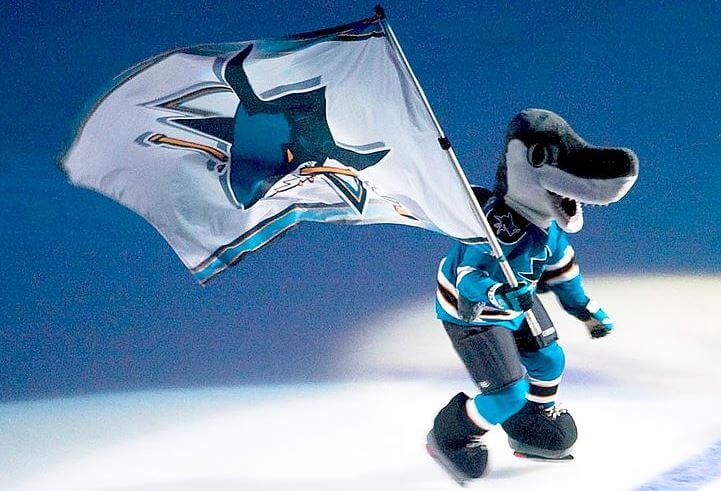 San Jose Sharks mascot skating with a team flag.