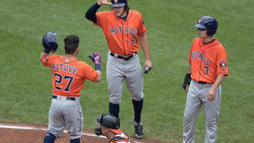 Astros teammates high-fiving at home plate