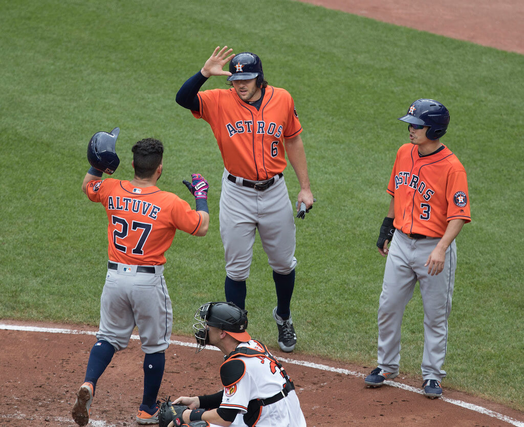 Astros teammates high-fiving at home plate