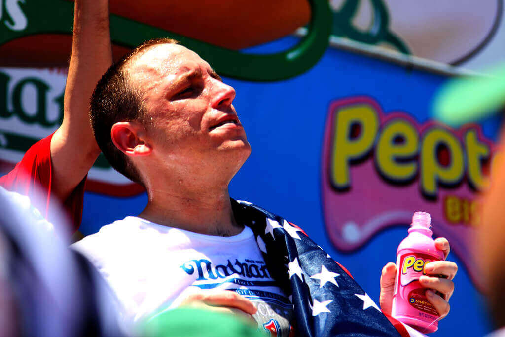 Joey Chestnut posing with titlle belt.