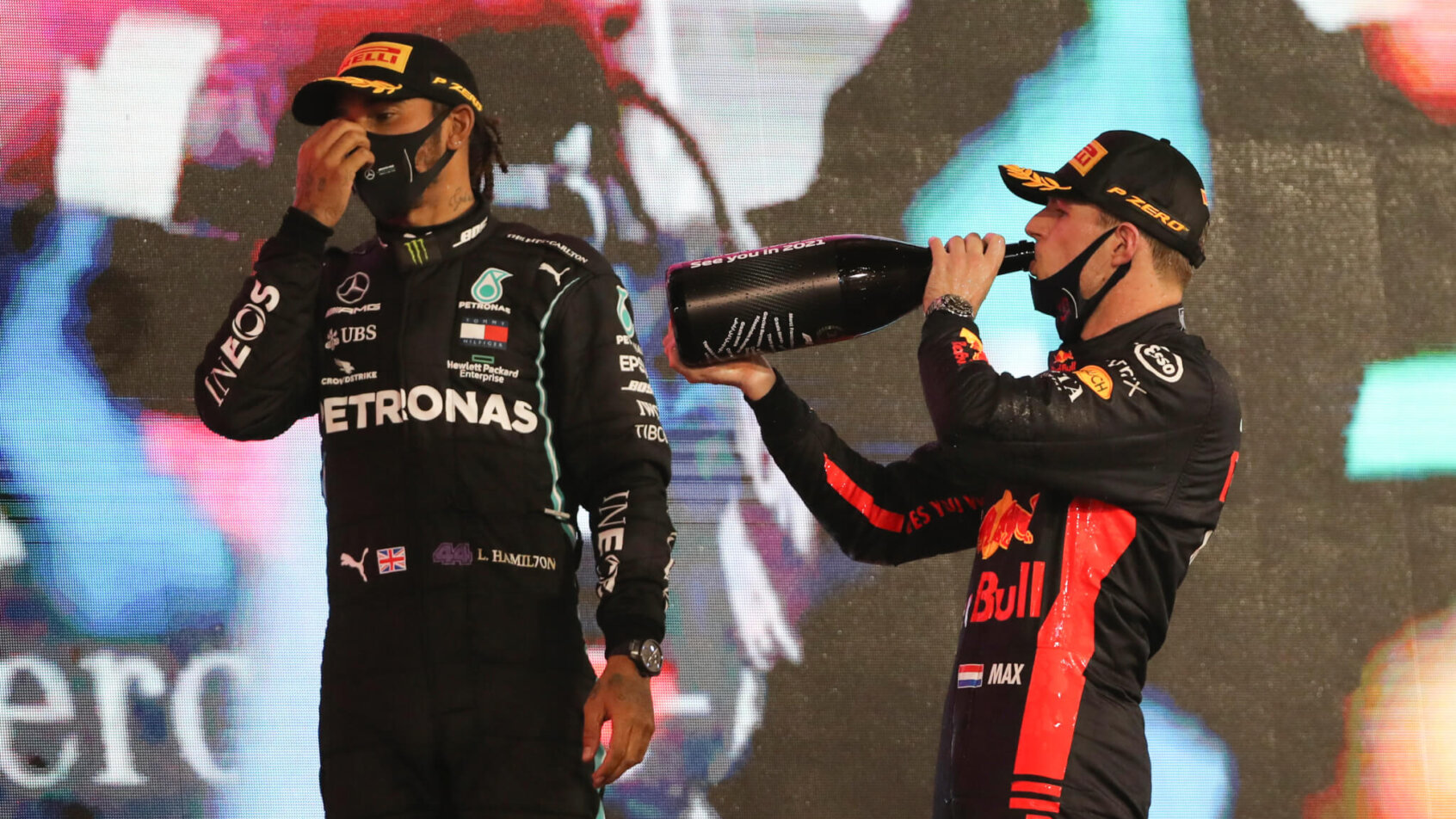 Mercedes driver Lewis Hamilton of Britain, left, and Red Bull driver Max Verstappen of the Netherlands stand on the winners podium in Abu Dhabi