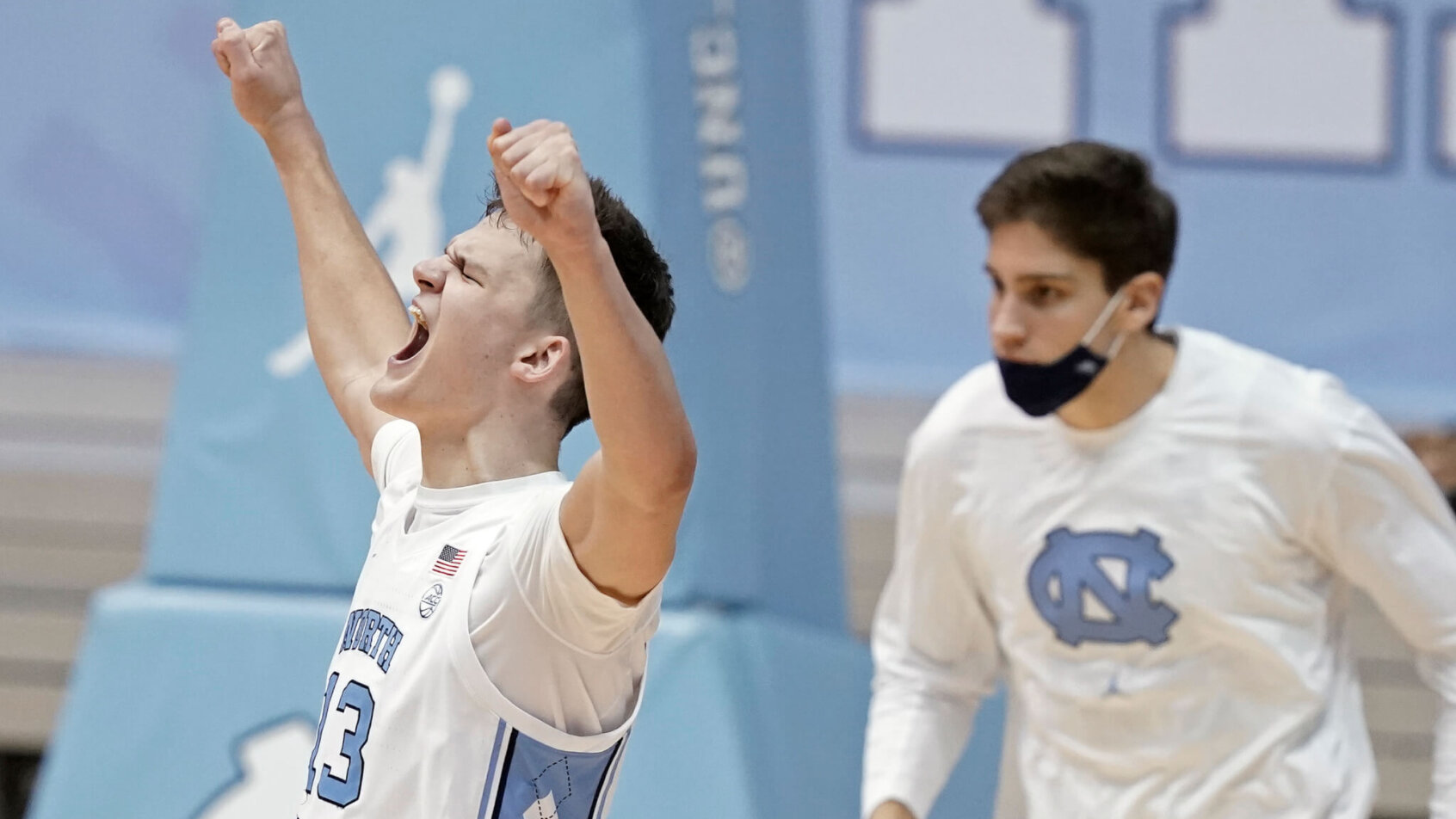 North Carolina forward Walker Kessler reacting and celebrating with his hands in the air during a NCAA men's basketball game.