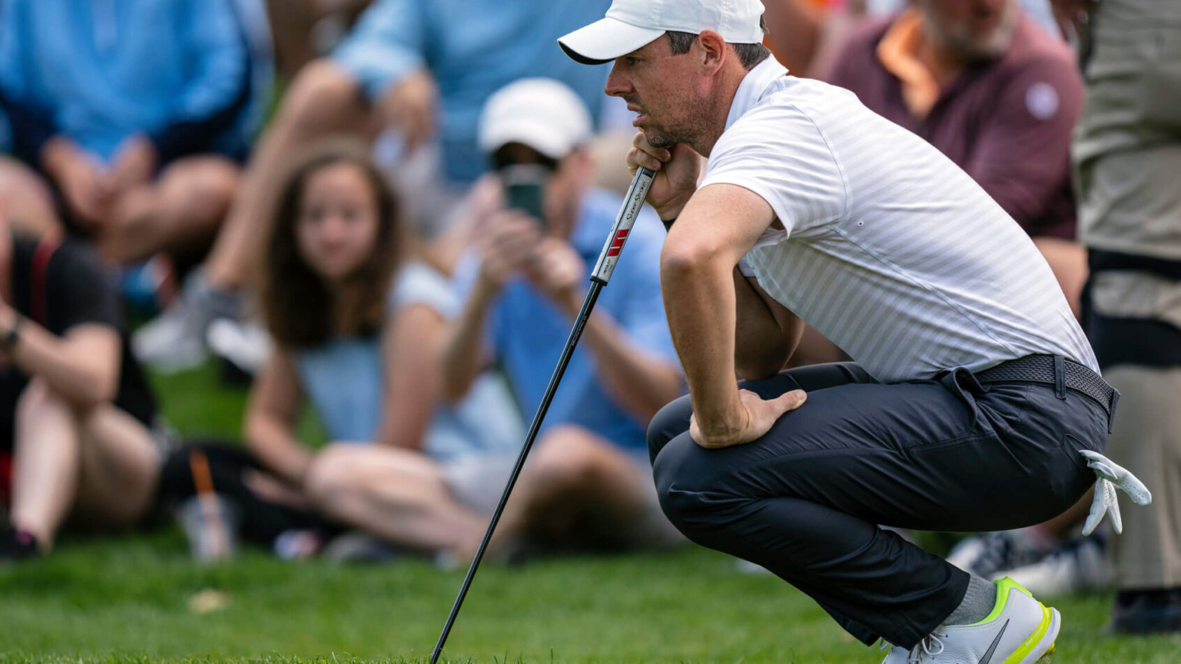 Rory Mcllroy lining up a shot during the third round of a golf tournament.