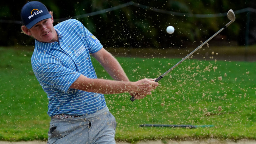 Brandt Snedeker hitting a ball out of a bunker during a golf tournament.