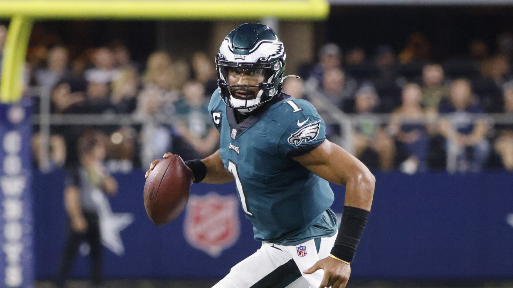 Jalen Hurts rolling out with football in right hand