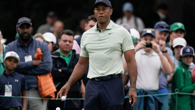 Tiger Woods watches a practice shot