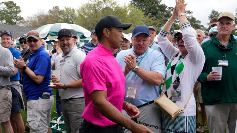 Tiger Woods walks past applauding fans