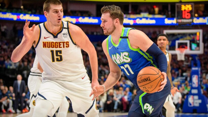 Luka Doncic dribbling as Nikola Jokic defends
