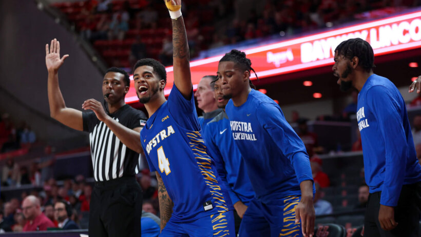 Hofstra players celebrating on the sideline