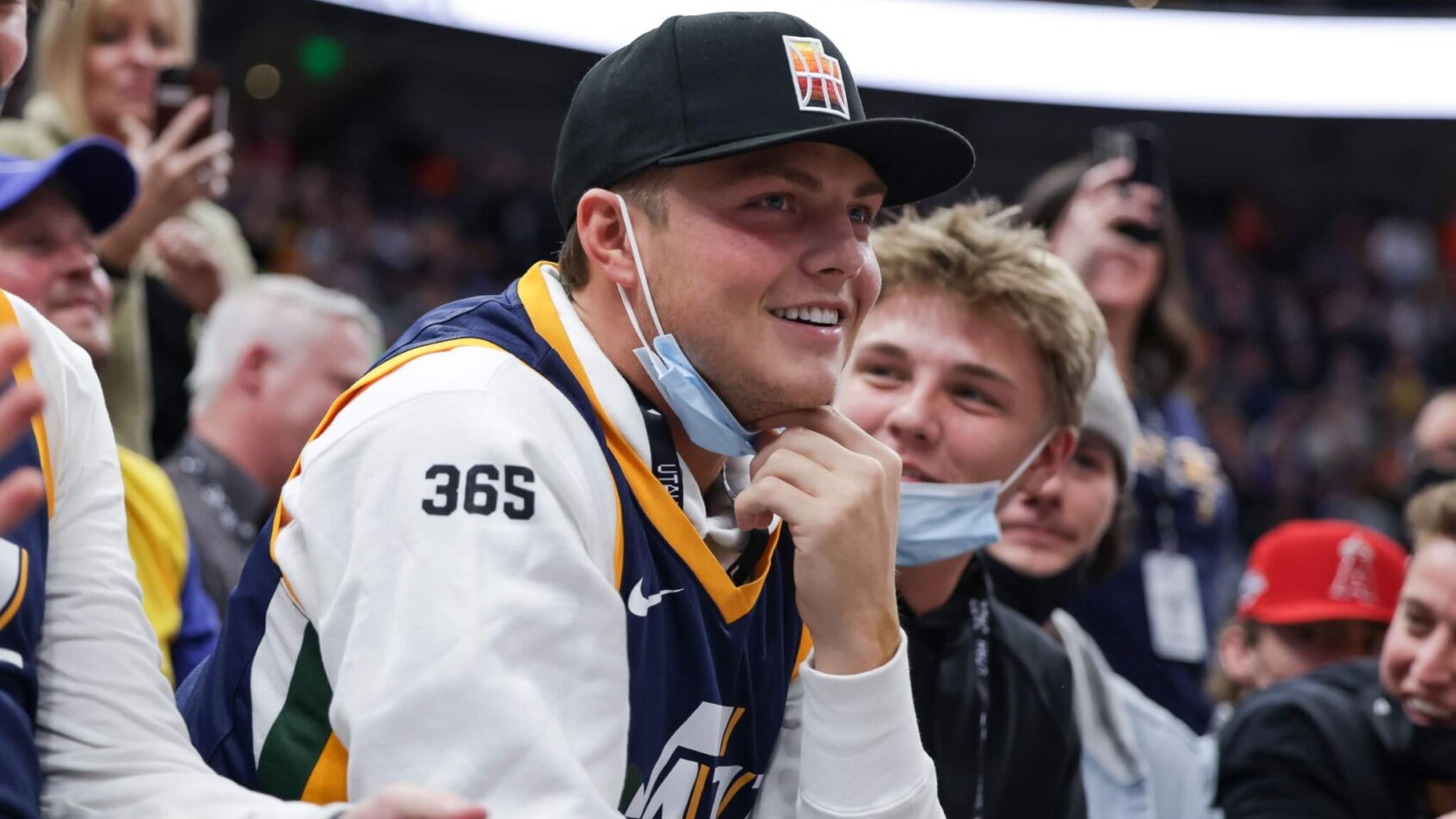 New York Jets quarterback Zach Wilson sits on court side watching the game between the Utah Jazz and the Golden State Warriors