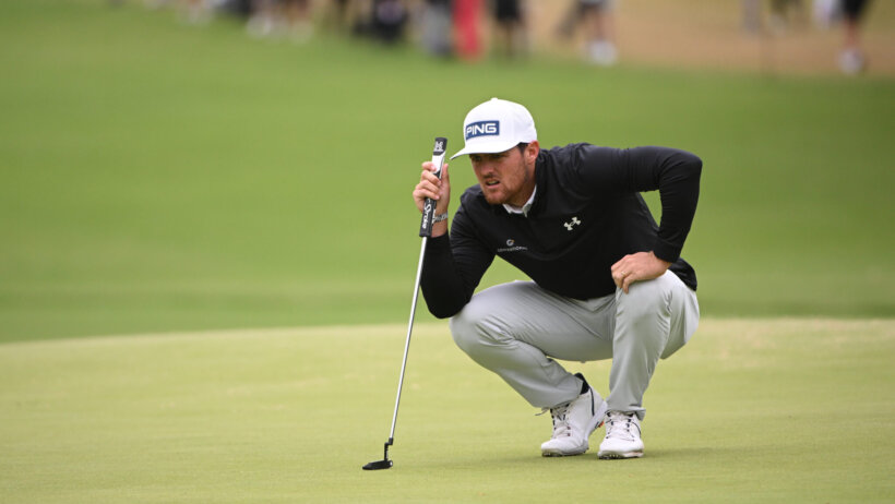 Mito Pereira squatting, lining up putt
