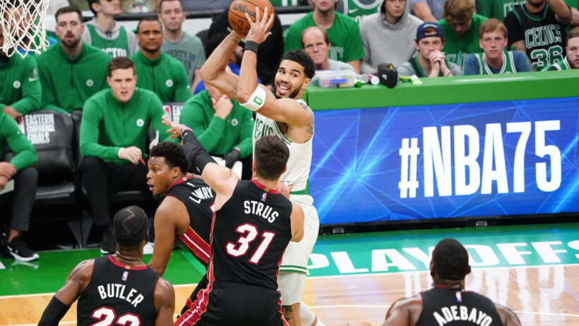 Boston Celtics forward Jayson Tatum holding the ball above his head