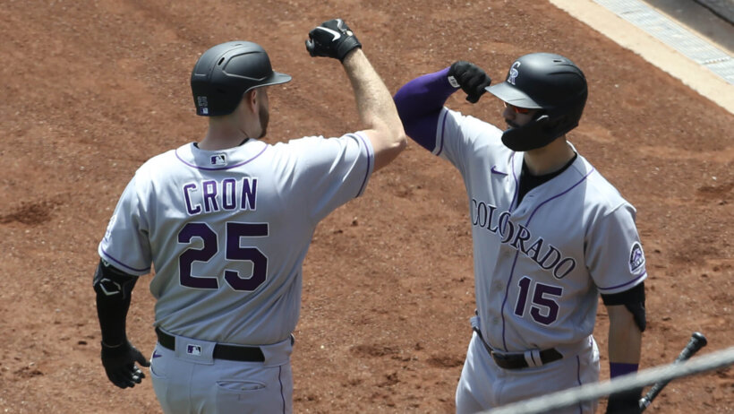 Colorado Rockies first baseman C.J. Cron elbow bumping with right fielder Randal Grichuk after hitting a homer