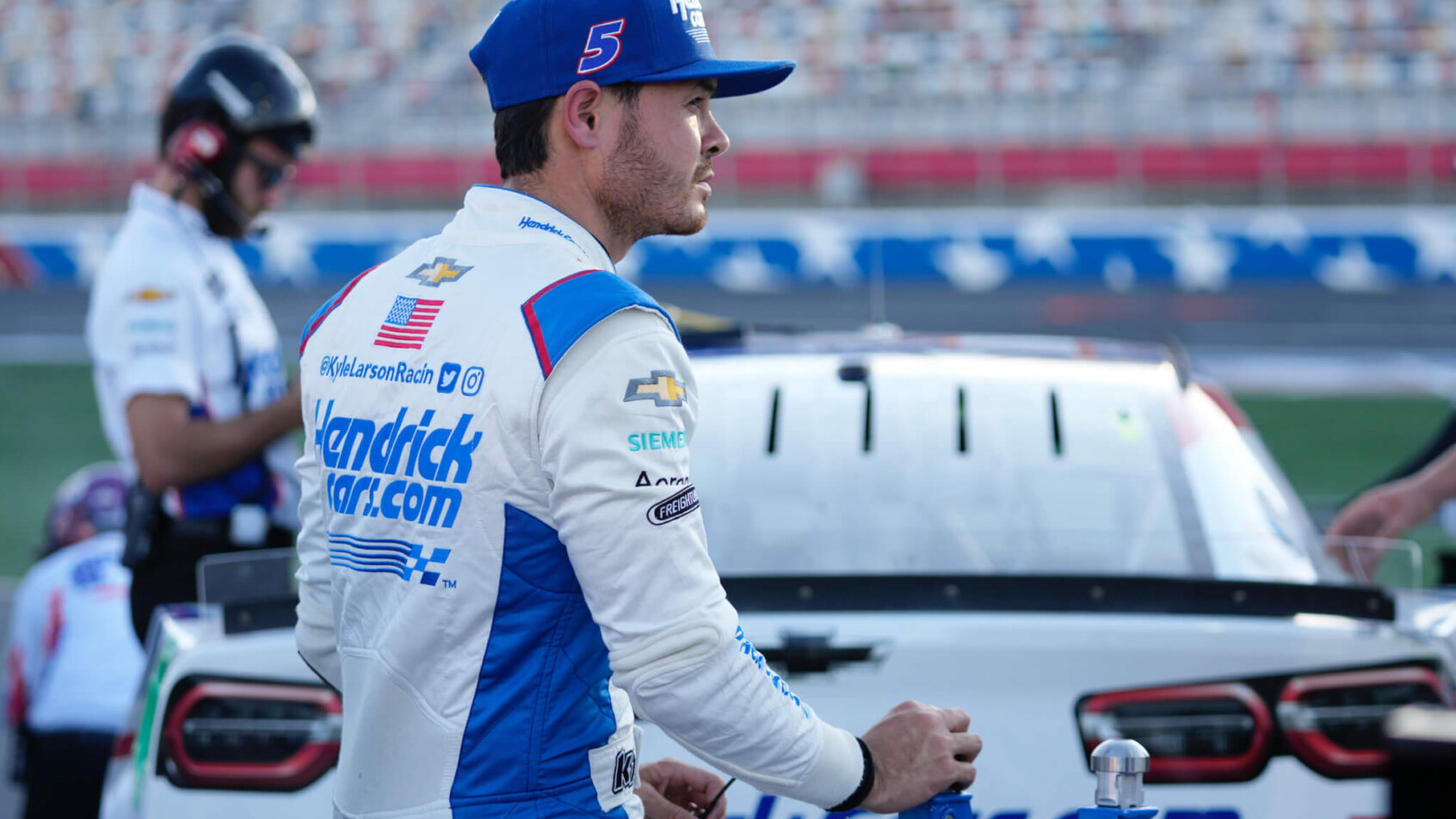 NASCAR Cup Series driver Kyle Larson standing next to his car