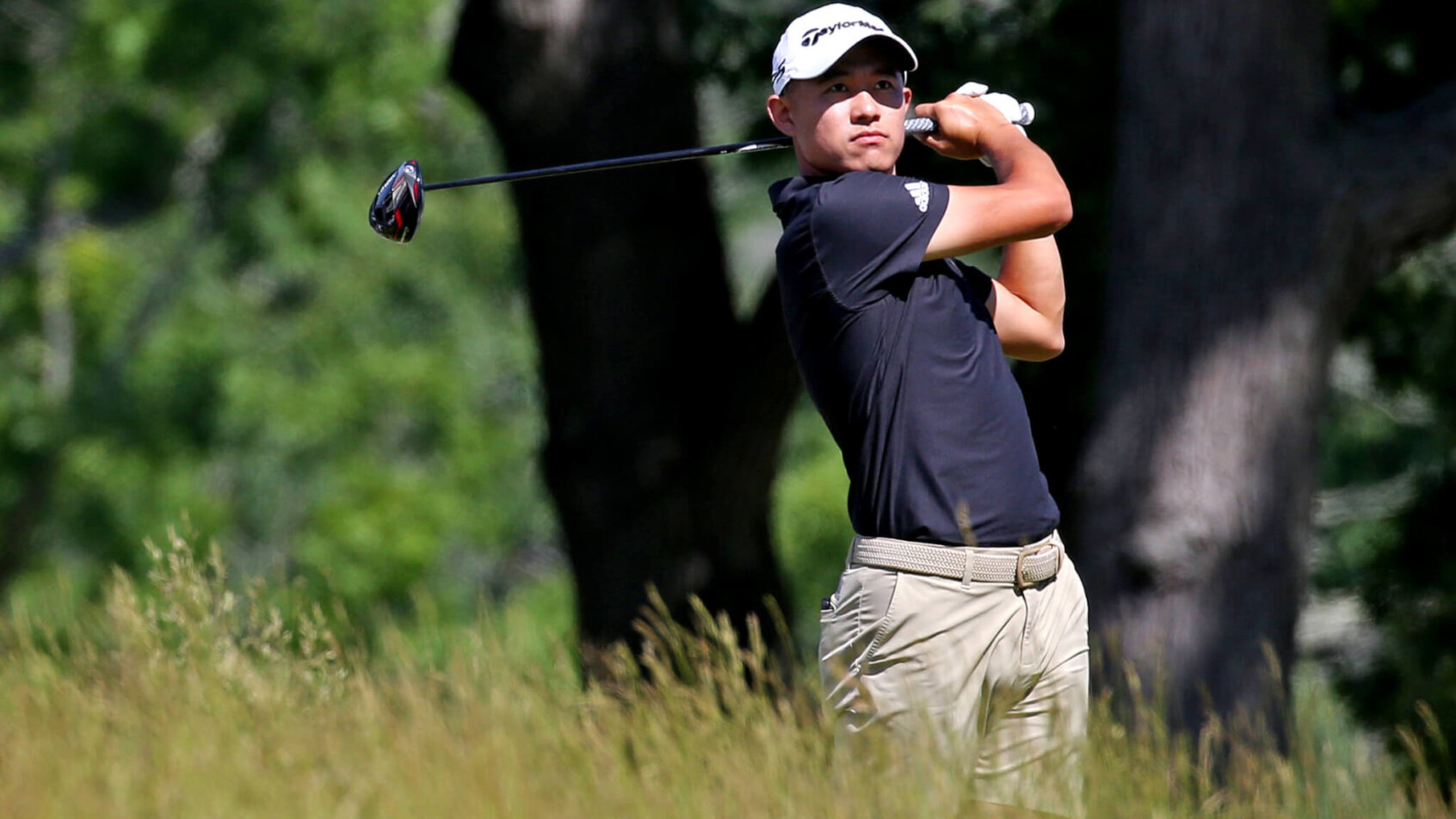 Collin Morikawa watches a tee shot intently