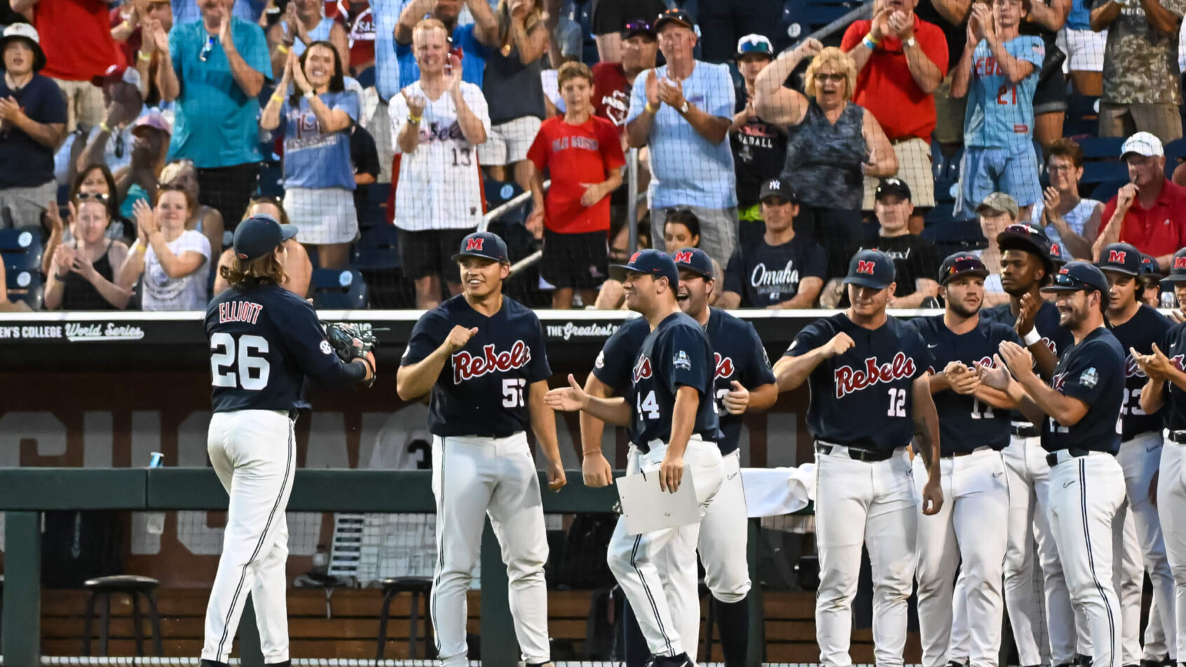 Ole Miss pitcher greets teammates during College World Series.