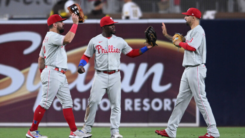 Philadelphia Phillies outfielders celebrating.