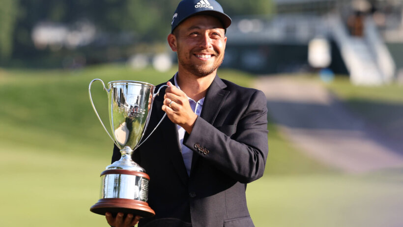 Xander Schauffele raising the Travelers Championship Trophy
