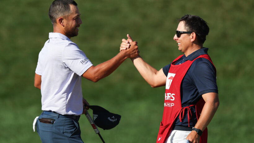 Xander Schauffele high-fives his caddie