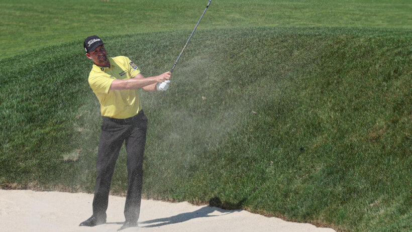 Webb Simpson hits a shot from a bunker