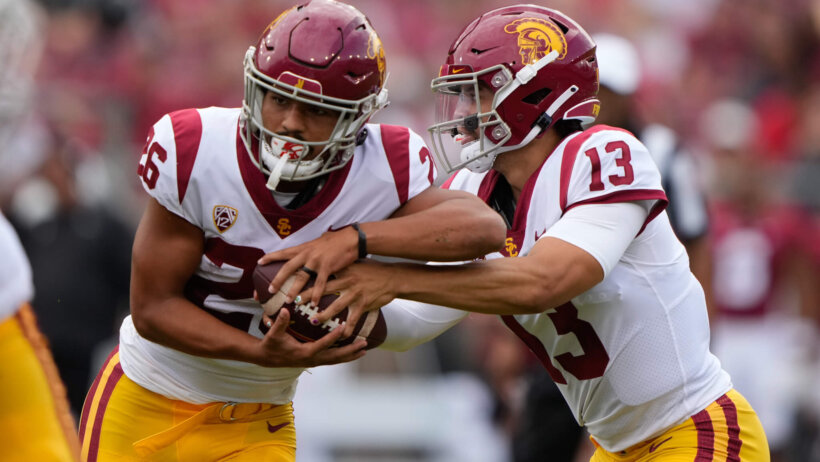 USC Trojans quarterback Caleb Williams hands the ball off to running back Travis Dye