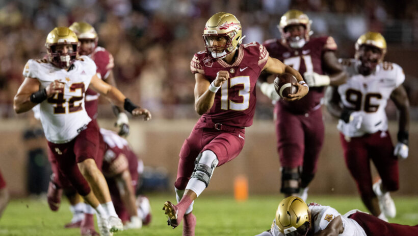 Florida State Seminoles quarterback Jordan Travis outruns a tackle