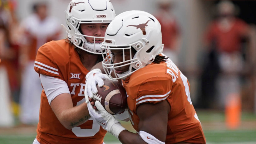 Texas Longhorns quarterback Quinn Ewers handing the ball off to running back Bijan Robinson