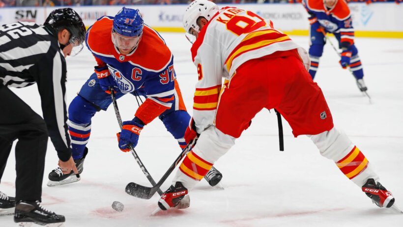 Edmonton Oilers forward Connor McDavid and Calgary Flames forward Name Kadri battle for a loose puck
