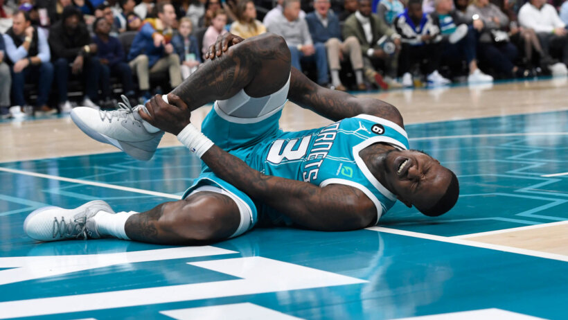 Charlotte Hornets guard Terry Rozier grabbing his injured leg