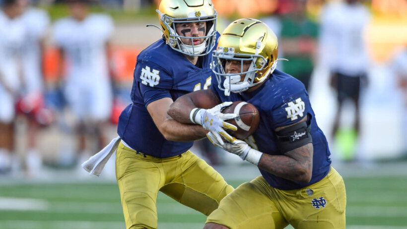 Notre Dame Fighting Irish quarterback Drew Pyne hands off to running back Logan Diggs