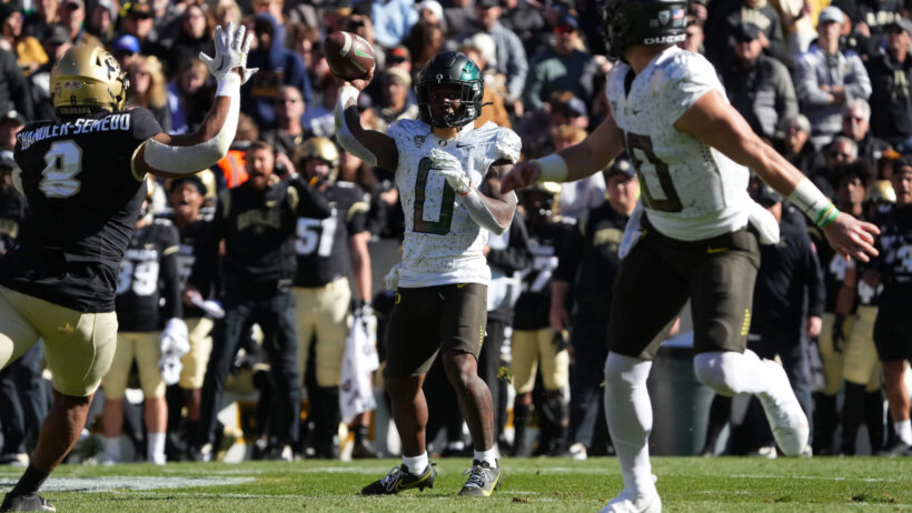 Oregon Ducks running back Bucky Irving passes the ball to quarterback Bo Nix