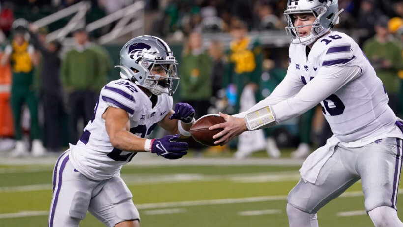 Kansas State Wildcats quarterback Will Howard hands the ball off to Kansas State Wildcats running back Deuce Vaughn