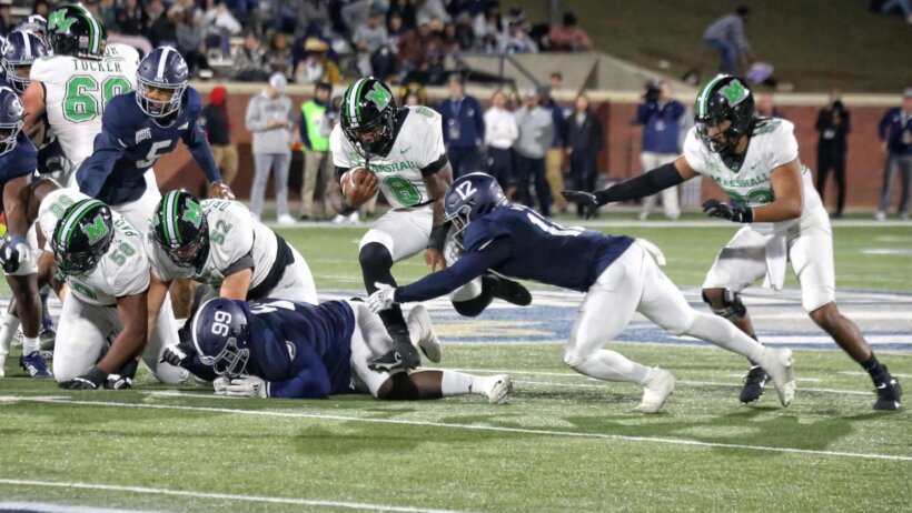 Marshall running back Khalan Laborn carries the football past safety