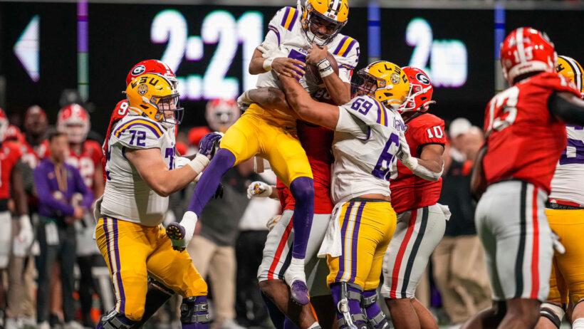 LSU Tigers quarterback Jayden Daniels is held in the air