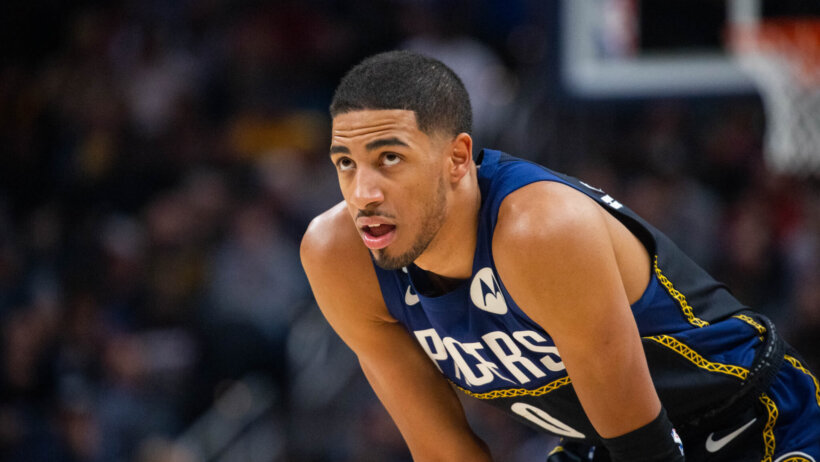 Indiana Pacers guard Tyrese Haliburton resting his hands on his knees during a game